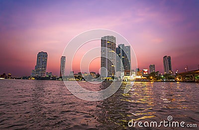 Chao Praya River in Bangkok, buildings and boats at sunset, Thailand Stock Photo