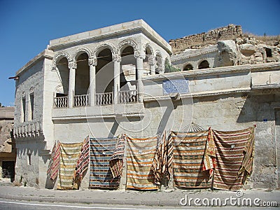 Building with pending carpets to Mustafapasa in Cappadocia in Turkey. Editorial Stock Photo