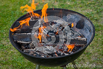 Charcoal barbecue grill, mobile brazier, burning wood Stock Photo