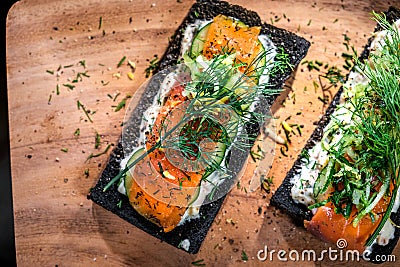 Charcoal Bread Smoked Salmon Sandwiches on wood board Stock Photo