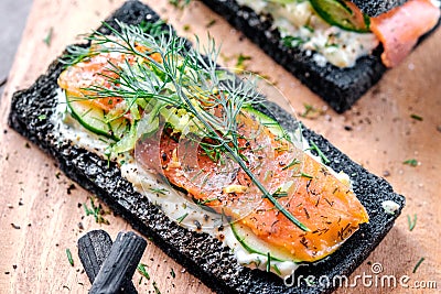 Charcoal Bread Smoked Salmon Sandwiches on wood board Stock Photo