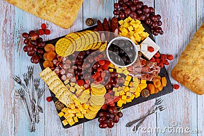 Charcuterie assortment, cheese, olives, fruits and prosciutto on wooden table Stock Photo