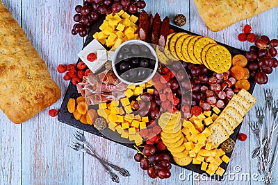 Charcuterie board assortment, cheese, olives, fruits and prosciutto on wooden table Stock Photo
