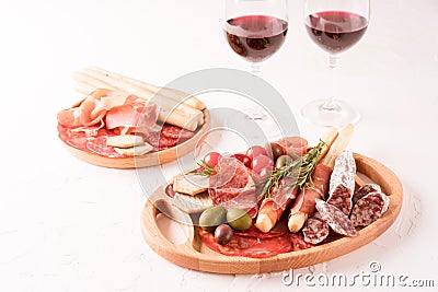 Charcuterie plate with different types of meat snacks. Wooden plates with traditional italian antipasti Stock Photo