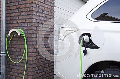 Charging of an electric car at home Stock Photo