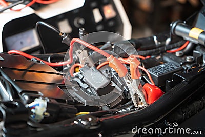 Charging motorcycle battery at garage, selective focus on Alligator clip ,concept of motorcycle maintenance and repair Stock Photo