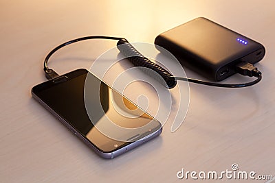 Charging smartphone with a power bank Stock Photo