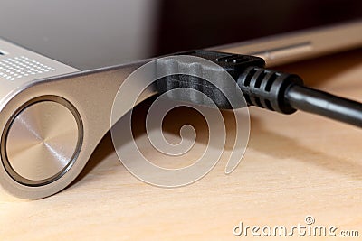 Charging the tablet. How to charge the battery. The charging cable and the tablet Stock Photo