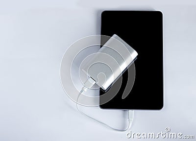 Charging tablet with portable external battery on white background Stock Photo