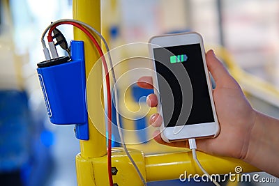 Charging your phone on the bus. Connecting the phone with wires to charge the battery in transport Stock Photo