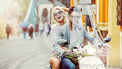 Charimgn lady riding a retro scooter with her boyfriend Stock Photo