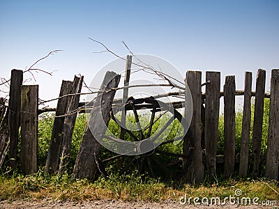 Chariot wheel on a wooden fence Stock Photo