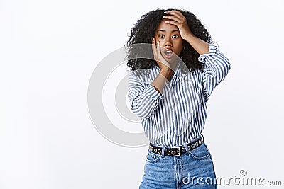 Charismatic attractive african american afro haircut woman open mouth gasping shocked grab head hands widen eyes Stock Photo