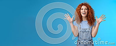 Charismatic bright happy amused redhead good-looking summer ginger girl raise hands delighted cheering flattered smiling Stock Photo