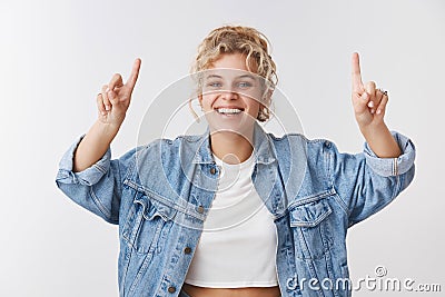 Charismatic good-looking happy smiling blond woman blue eyes fit body pointing up inviting join favorite gym excercise Stock Photo