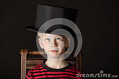 Charismatic little boy wearing an out size top hat Stock Photo