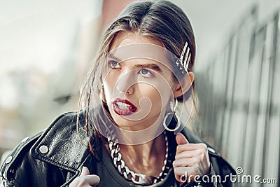 Charismatic long-haired woman with bright makeup and aggressive outfit Stock Photo