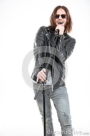 Charismatic male singer in sunglasses standing and singing into micophone Stock Photo