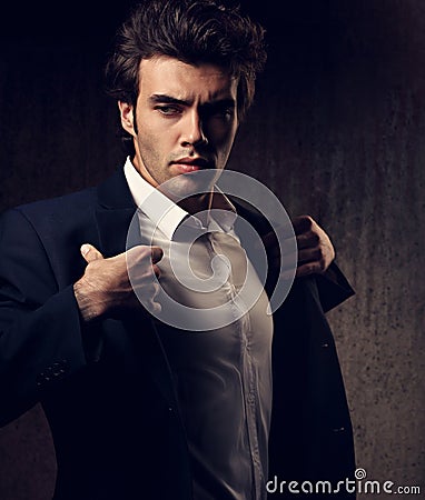 Charismatic male model posing and holding the fashion suit Stock Photo