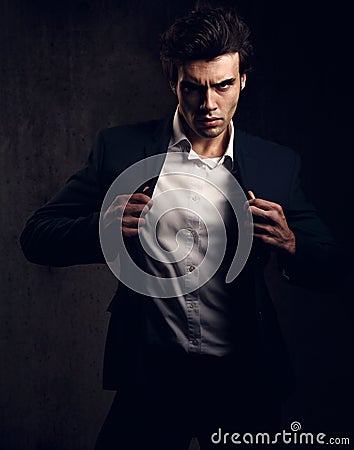 Charismatic male model posing and holding the fashion suit Stock Photo