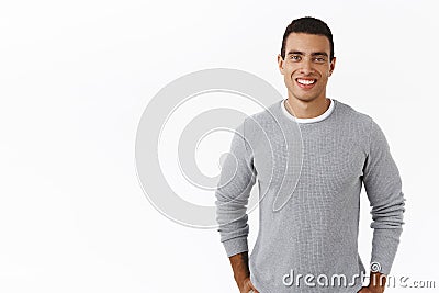 Charismatic young man in grey sweater smiling friendly camera, meeting girlfriend friends first time, getting know team Stock Photo