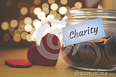 Charity money jar with blurred lights Stock Photo