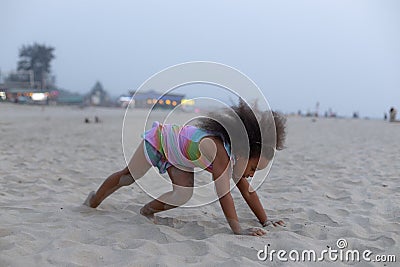 Charming African American girl is doing sports on summer day at beach. Outdoor activities. Stock Photo