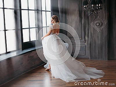 Charming angel in snow-white dress dancing in castle tower with large windows, a new story about Cinderella and Snow Stock Photo
