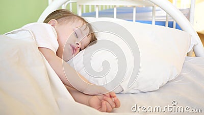 Charming baby falls asleep on white bed in his bed in room at home. concept of sleeping child. child wants to sleep and Stock Photo