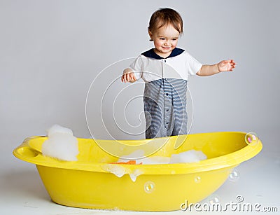 Charming baby standing near bathtub Stock Photo