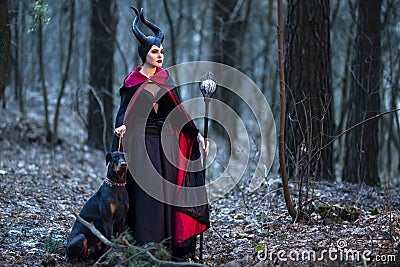 Charming and Beautiful Maleficent Woman with Highbred Dog on Leash. Posing Together in Early Spring Forest Editorial Stock Photo