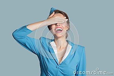 Charming happy beautiful stewardess on blue background Stock Photo