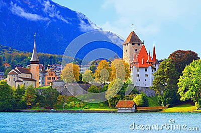 Charming church on lakeside bank of Thun City, on mountain under blue sky background. Stock Photo