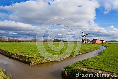 Charming Dutch windmill on green grassland Stock Photo