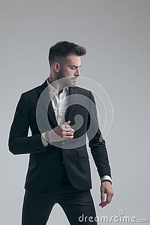 Charming elegant man fixing his jacket and looking away Stock Photo