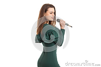 Charming girl in a green dress sings in a microphone Stock Photo