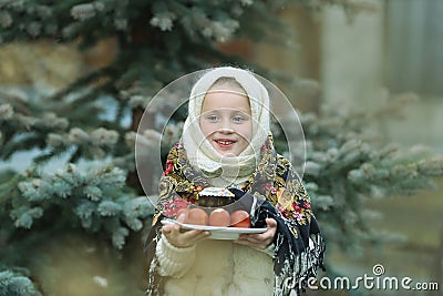 Charming girl in Russian chalet holding a plate with Easter eggs Stock Photo