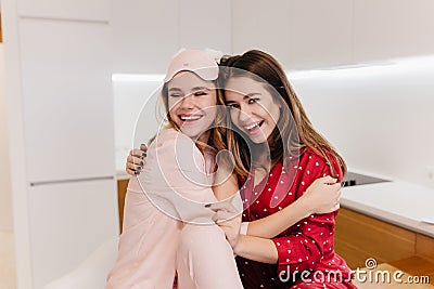 Charming girl in sleepmask smiling with eyes closed. Refined long-haired female model in stylish pajamas expressing Stock Photo