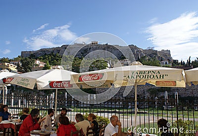 Charming Greek taverna in the historic city of Athens, with the classical Acropolis in the background Editorial Stock Photo