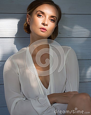 Charming hipster female model on a wooden fence background in a white T-shirt Stock Photo
