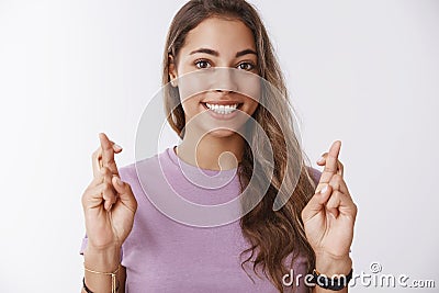 Charming hopeful girlfriend keeping high hopes cross fingers good luck smiling broadly anticipating dream come true Stock Photo