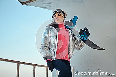 Charming lady with snowboard is posing for photographer Stock Photo