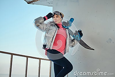 Charming lady with snowboard is posing for photographer Stock Photo