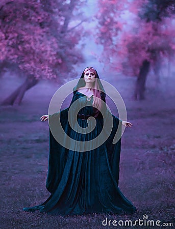 Charming maiden in a blue brakhatny cloak in a wide belt, with pink hair in the forest as a sacrifice for the devil. the Stock Photo