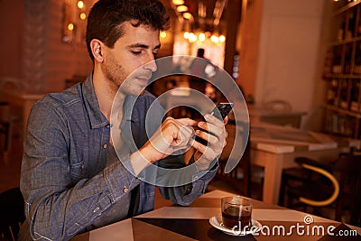 Charming millenial texting in a restaurant Stock Photo