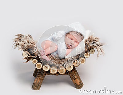 Newborn baby asleep on belly curled up on crib Stock Photo