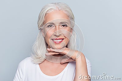 Charming old woman holding hand under chin with beaming smile lo Stock Photo