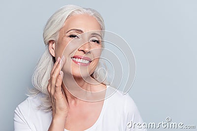 Charming, pretty, old woman touching her perfect soft face skin Stock Photo
