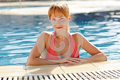 Charming slender red-haired girl in a swimsuit at the pool in th Stock Photo