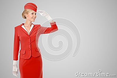 Charming Stewardess Dressed In Red Uniform On Gray Background. Stock Photo